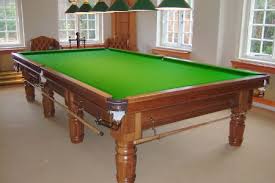 A pool table that was just refelted with new green felt by North Coast Pool Tables